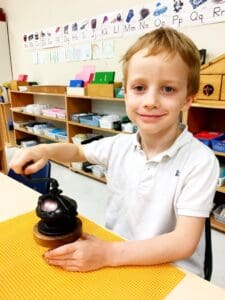 Child operating a educational tool in class.