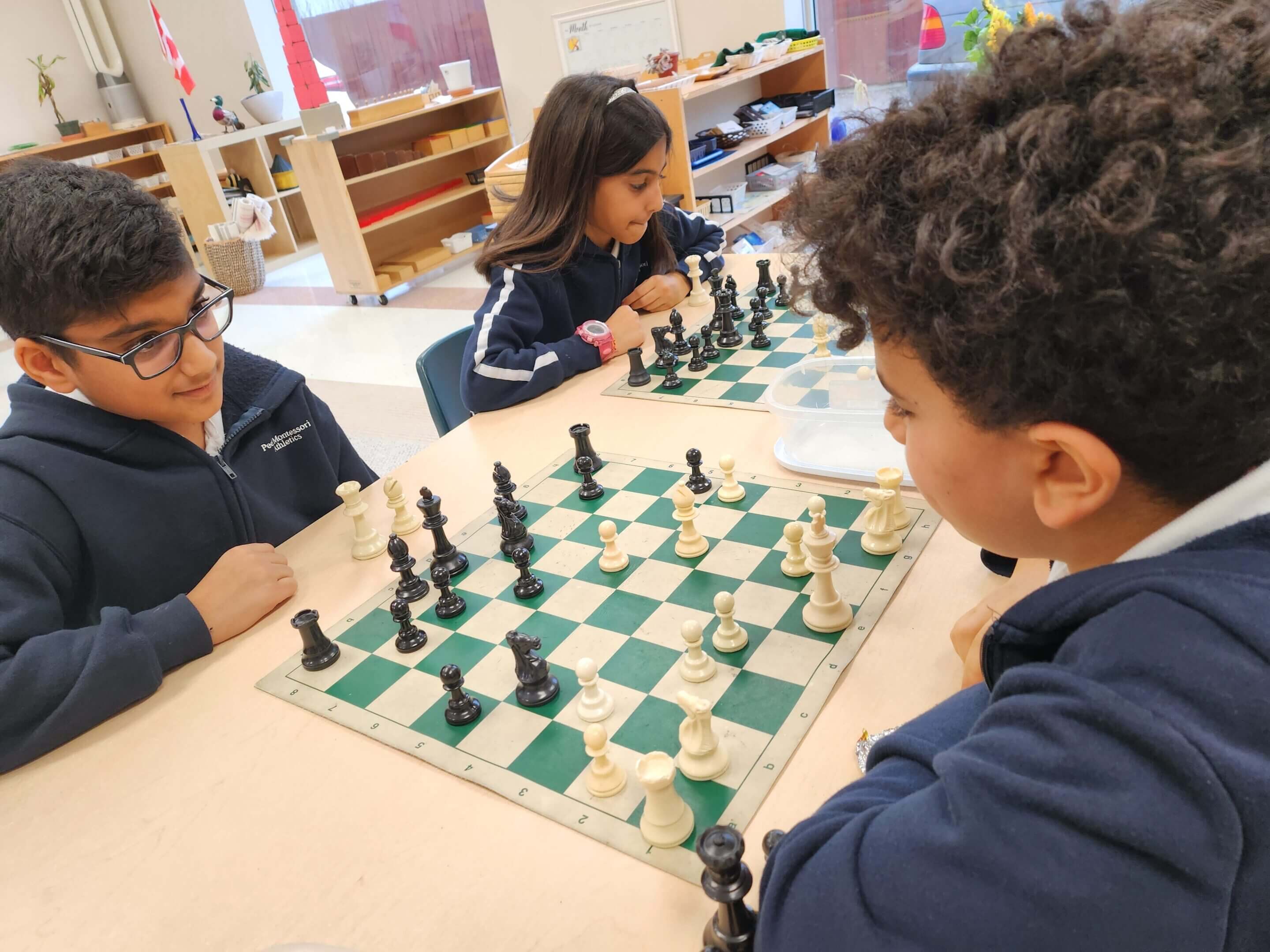 Children playing chess in a classroom.