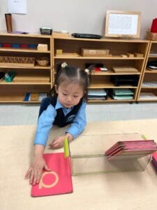 Child arranging colorful educational materials at table.