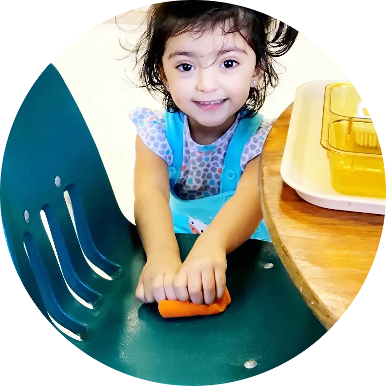 Smiling child playing with orange object.