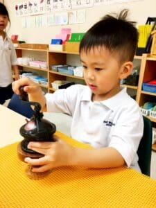 Child using a wooden toy in classroom.