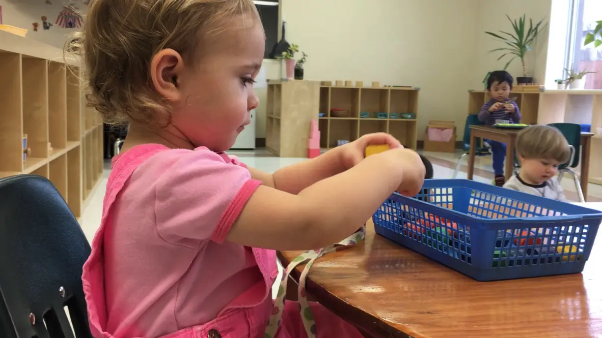 Young child playing with colorful blocks indoors.