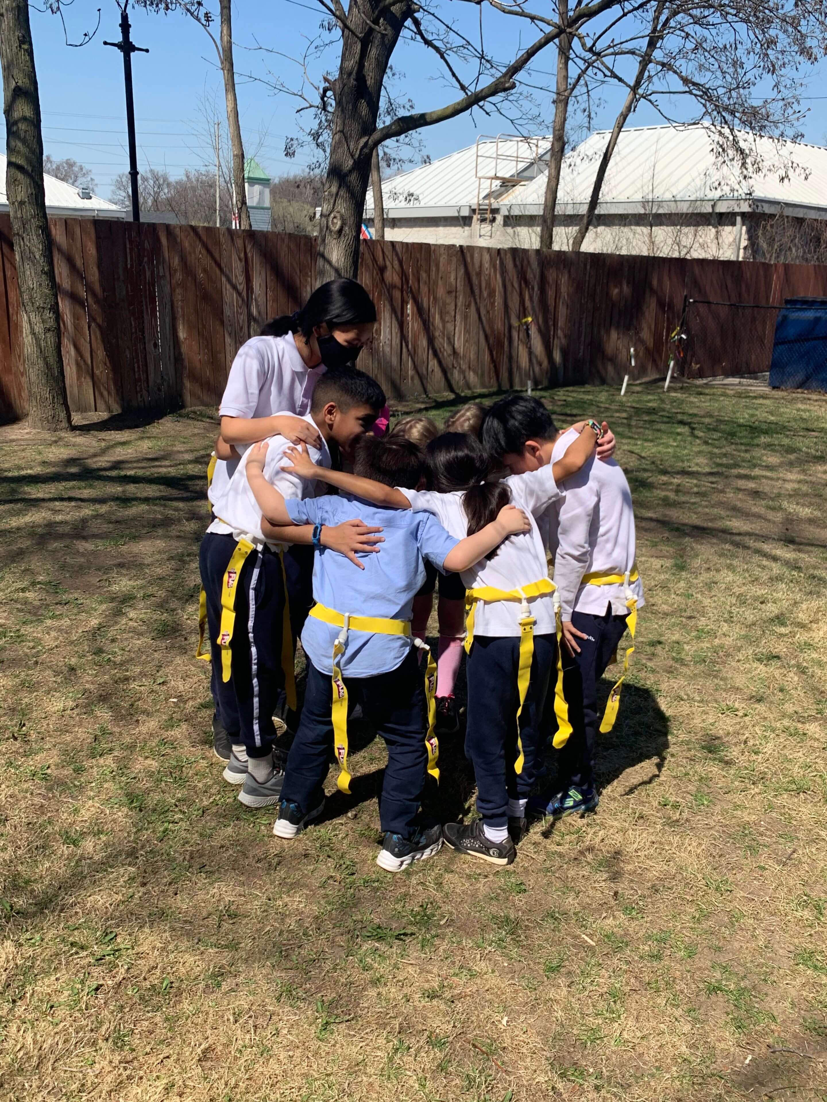 Children in outdoor group activity huddle.