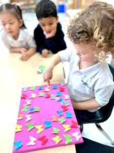 Children crafting with colorful butterfly cutouts.