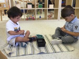 Two children playing on a striped rug.