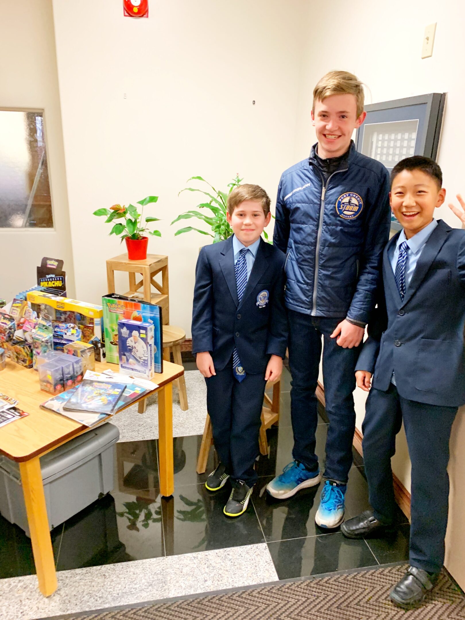 Boys in suits standing with toys.