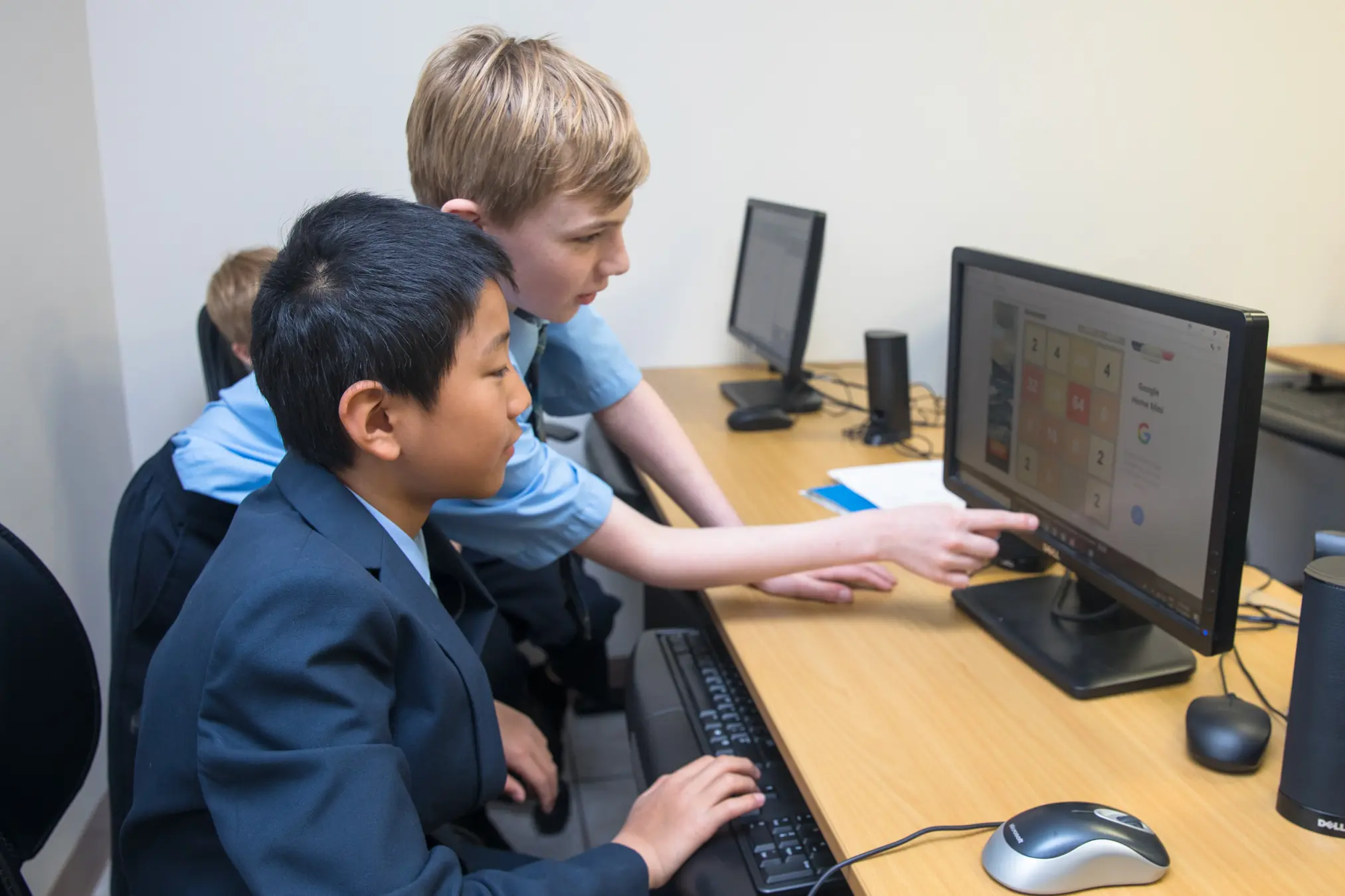 Two children collaborate at a computer.