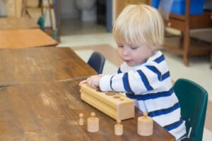 Child playing with wooden learning toys.