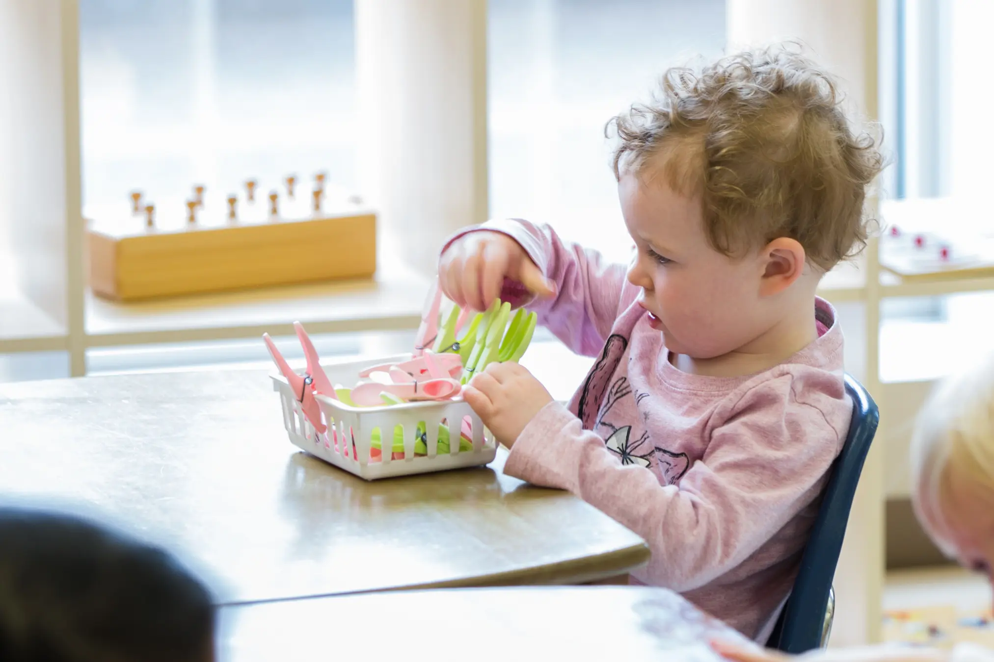 Child playing with colorful plastic utensils.