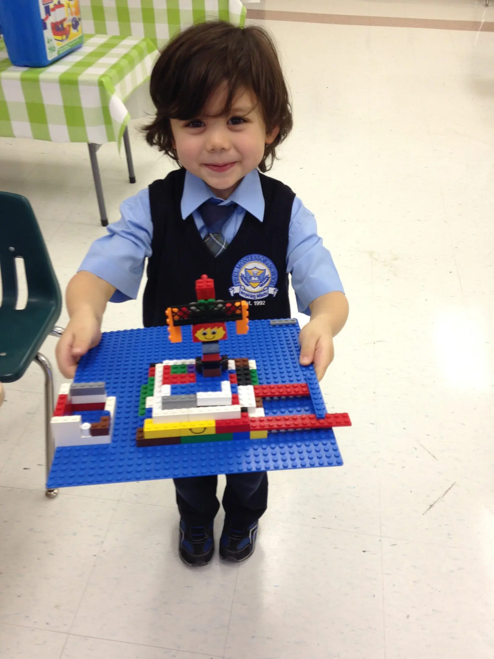 Smiling boy holding a colorful LEGO creation.