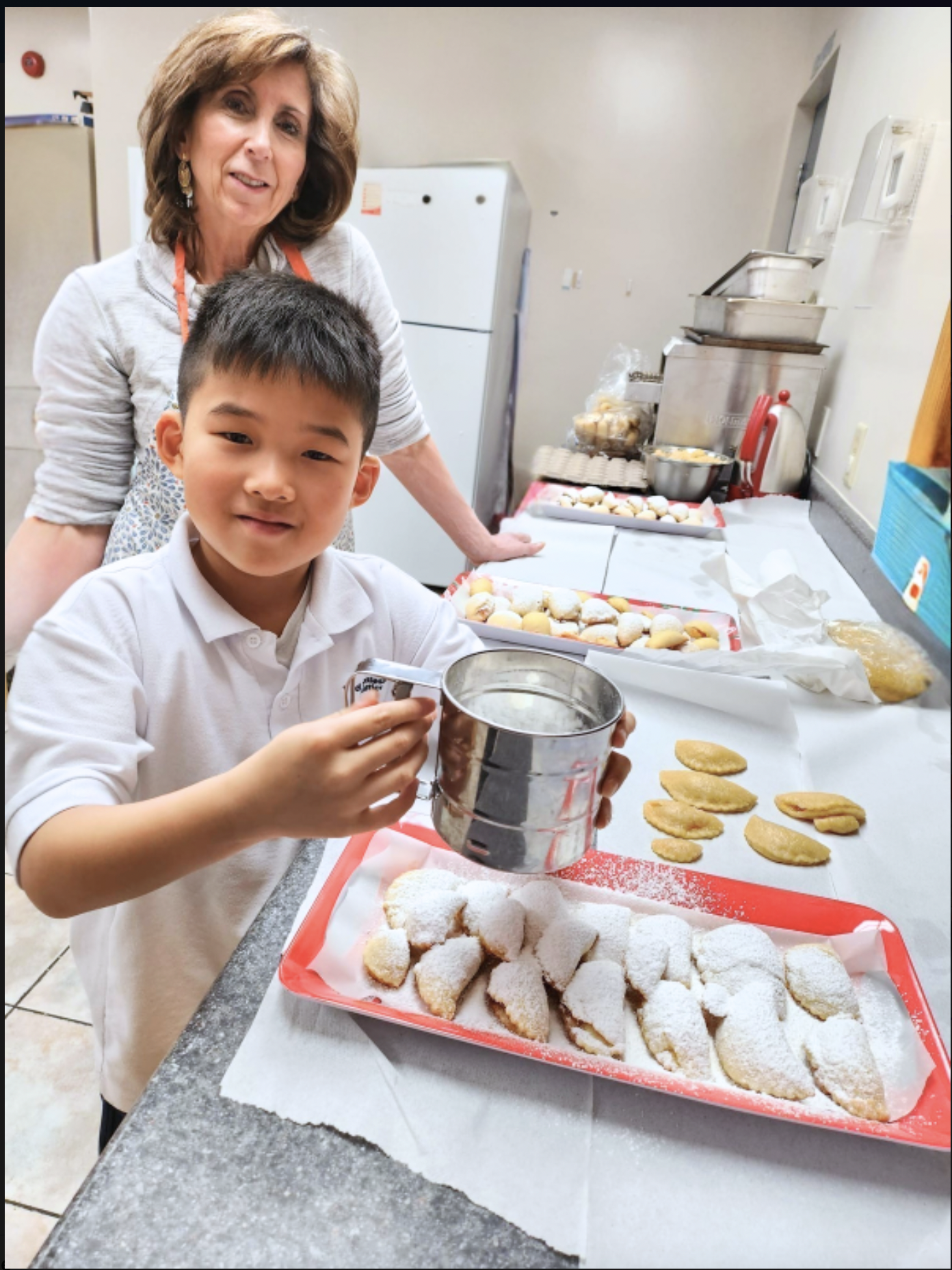 Baking together: child and adult with pastries.